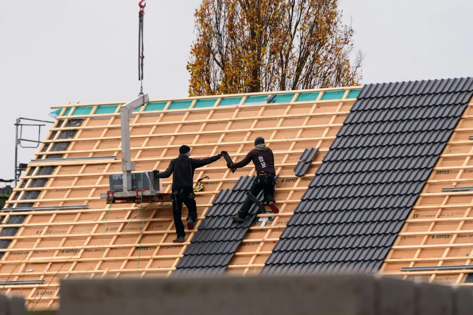 Roofers fitting tiles on a pitched roof
