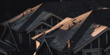 Row of modern tiled rooftops in sunlight, showing possible summer wear and tear
