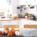 A sparkling UK kitchen after an autumn deep clean, with tidy cupboards, a gleaming oven, and seasonal touches like pumpkins on the counter.