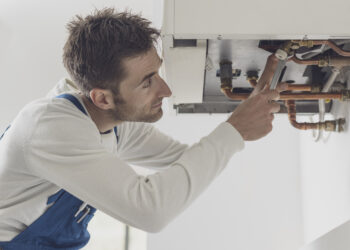 Gas Safe engineer servicing a household boiler in autumn, ensuring heating safety and efficiency before winter.