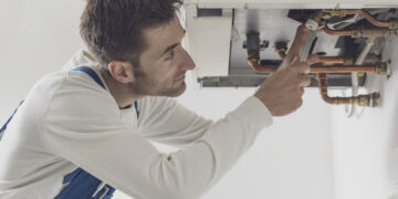 Gas Safe engineer servicing a household boiler in autumn, ensuring heating safety and efficiency before winter.