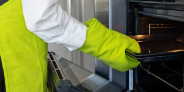 Oven cleaning in a UK kitchen showing a clean, grease-free oven interior with shining racks and a clear glass door after professional cleaning.