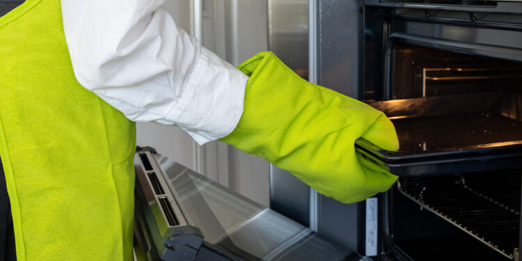 Oven cleaning in a UK kitchen showing a clean, grease-free oven interior with shining racks and a clear glass door after professional cleaning.