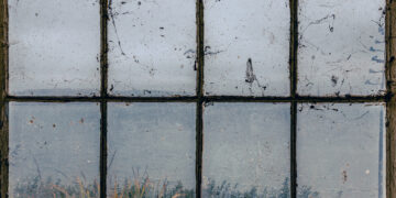 Sunlight highlighting streaky window glass in a UK home before professional window cleaning restores a clear, polished finish.