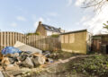 Backyard with a pile of household and construction waste awaiting rubbish clearance in a UK garden