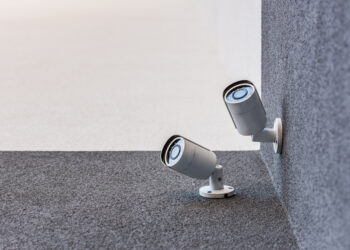 Smart home security camera monitoring a house exterior as part of a modern home security system