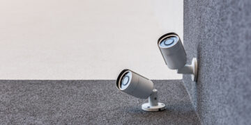 Smart home security camera monitoring a house exterior as part of a modern home security system