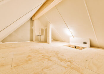 Unboarded loft space with exposed joists and insulation, showing limited usable storage area