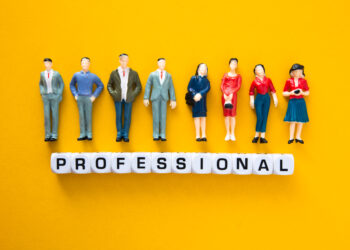 Miniature figures representing vetted professionals standing above letter blocks spelling “professional”, symbolising the process of vetting local professionals and background checks for trades in the UK.