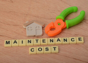 Tools and house model with maintenance cost text representing seasonal home maintenance checklist for UK homeowners