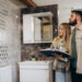 Couple reviewing bathroom renovation options in a showroom with modern wall tiles, vanity unit, and contemporary bathroom fittings.