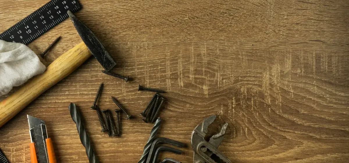 Hand tools laid out on a wooden board for a repair job