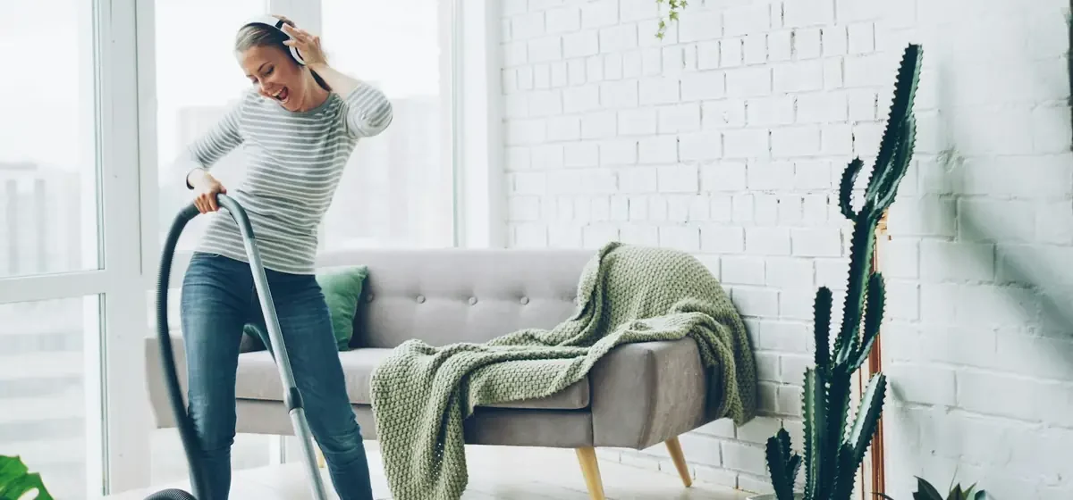 Woman vacuuming the floor of a bright living room