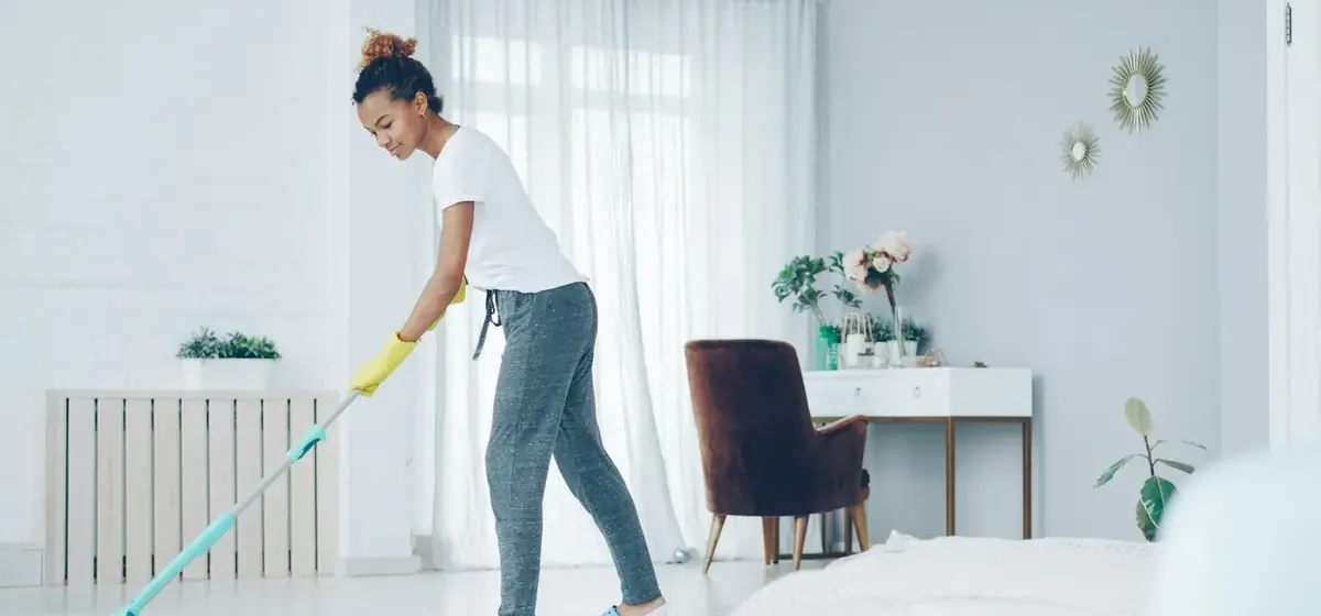 Person mopping a hard floor in a living room