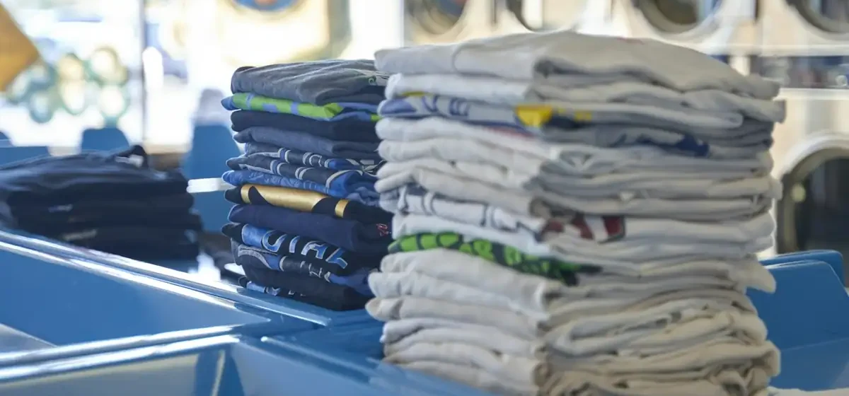 Stack of neatly folded shirts on a blue table