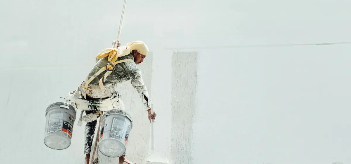 Decorator rolling fresh white paint onto an interior wall