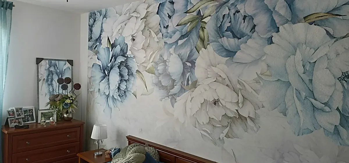 Freshly decorated bedroom with floral wallpaper and made bed