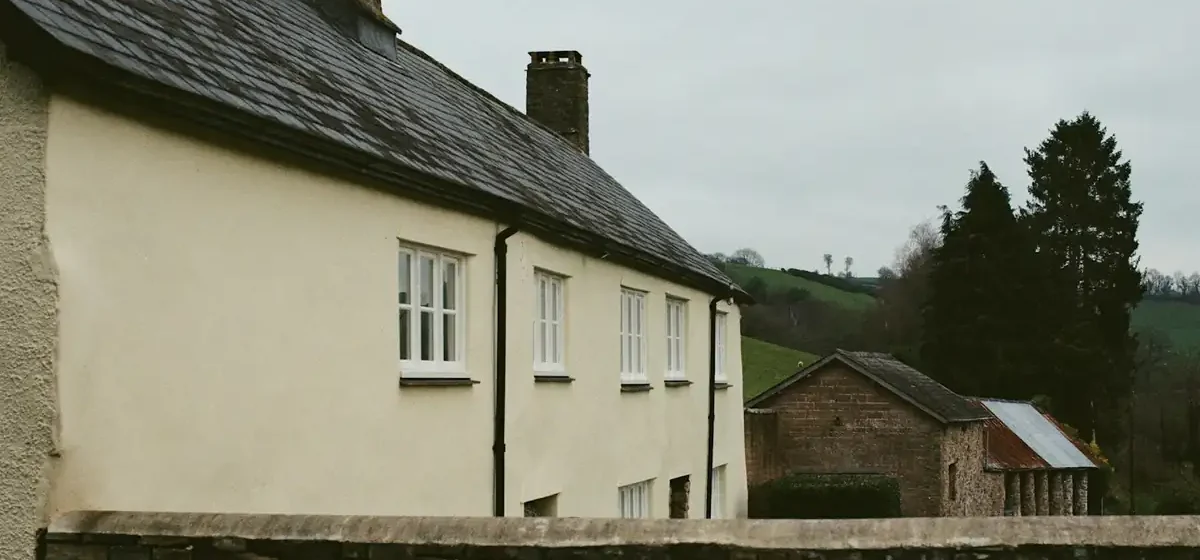Cream rendered house wall beside a stone garden wall