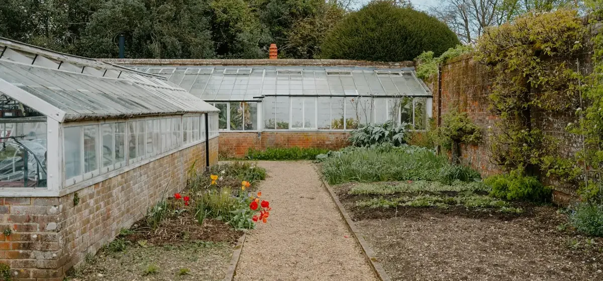 Walled kitchen garden with greenhouses and bare vegetable beds