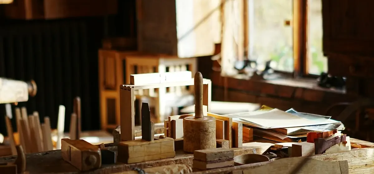 Hand tools laid out on a sunlit wooden workbench