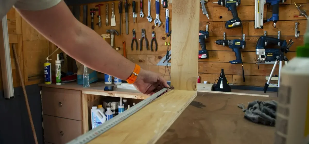 Carpenter fitting a wooden frame indoors