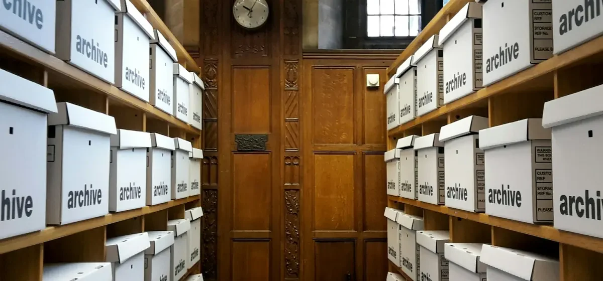 Rows of white storage boxes stacked on wooden shelving