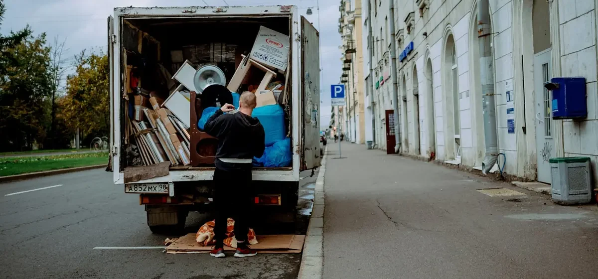 Worker lifting furniture out of the back of a van