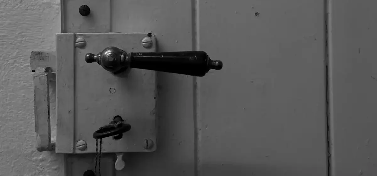 Close-up of an old door handle and lock with a key
