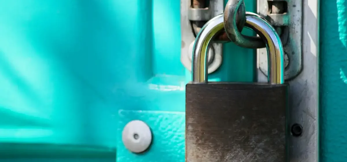Padlock fastened to a painted timber door