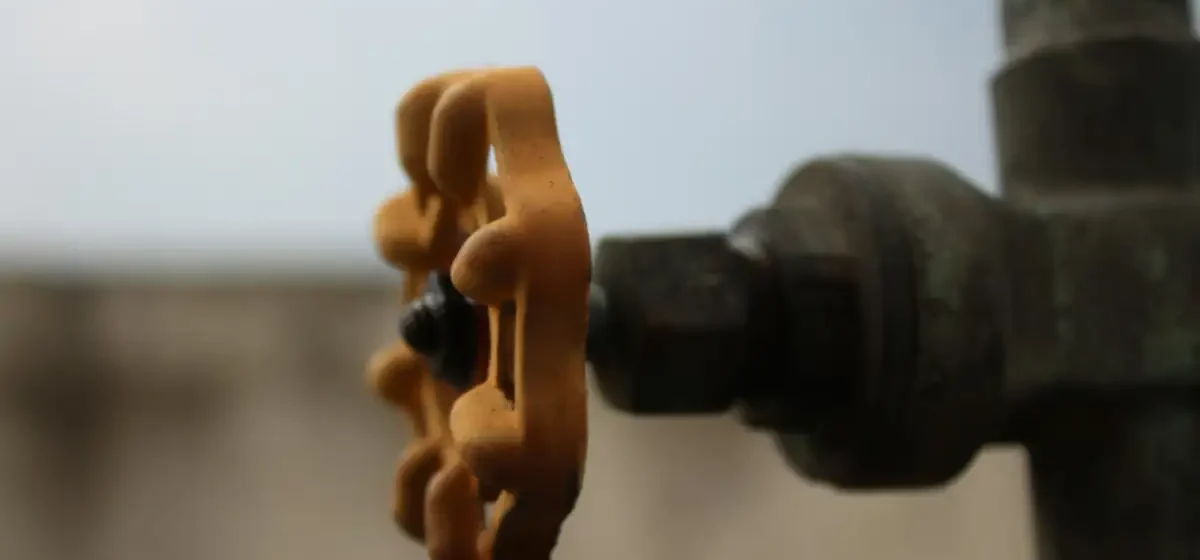 A shut-off valve handle on a metal water pipe