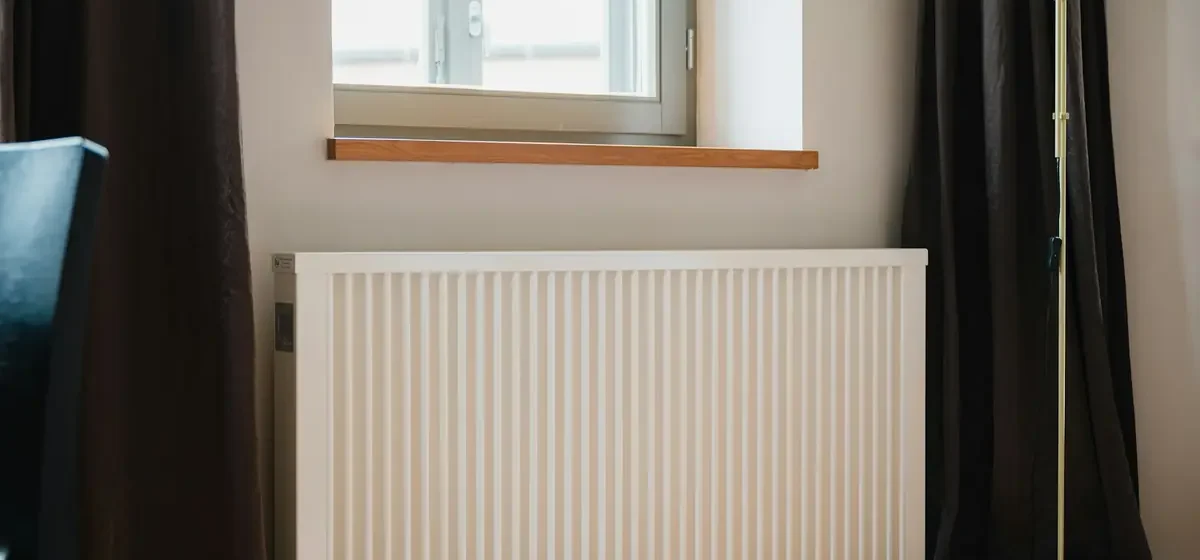 White panel radiator beneath a window in a room