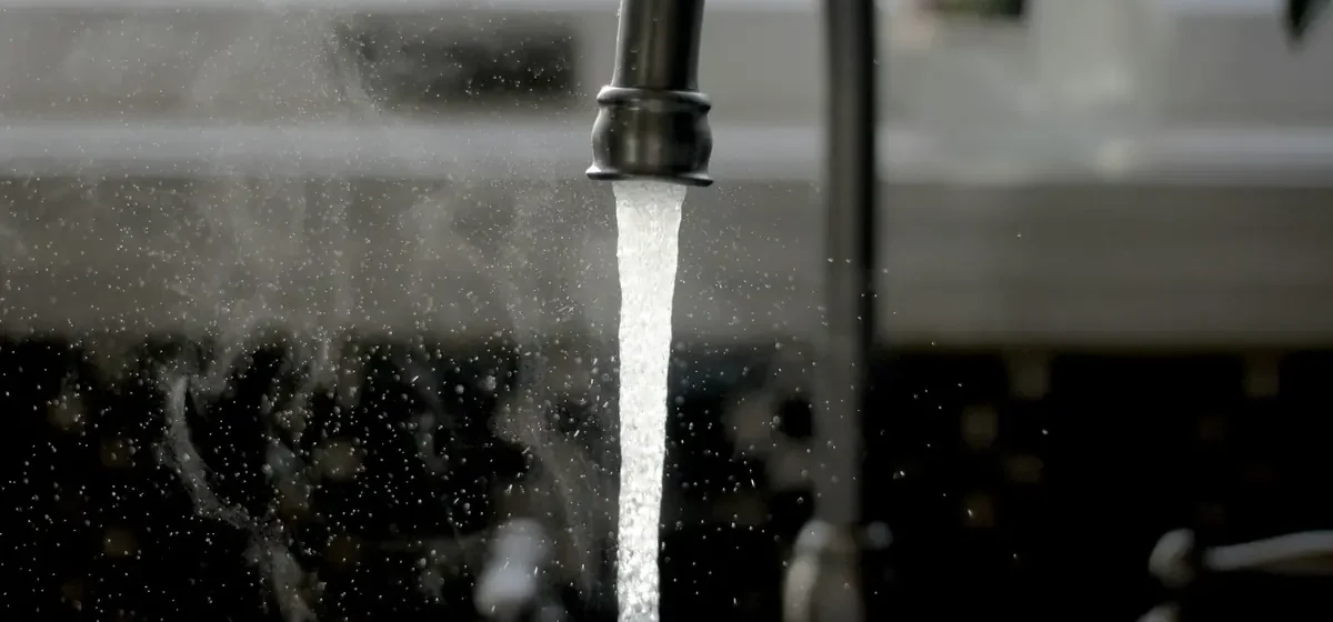 Water running from a mixer tap into a kitchen sink