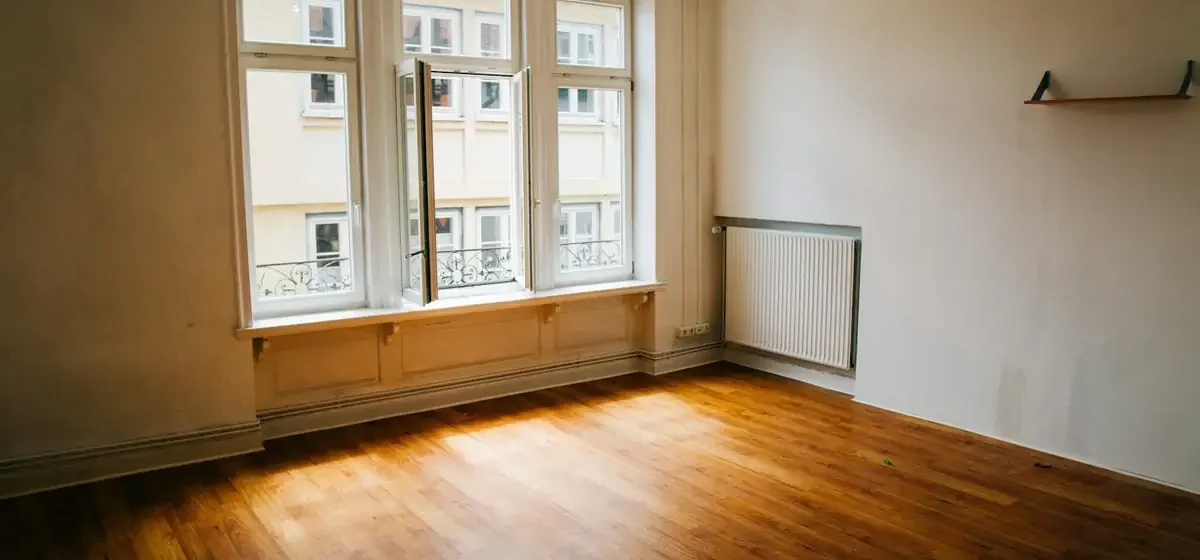 Empty room with wooden floor and tall sash windows