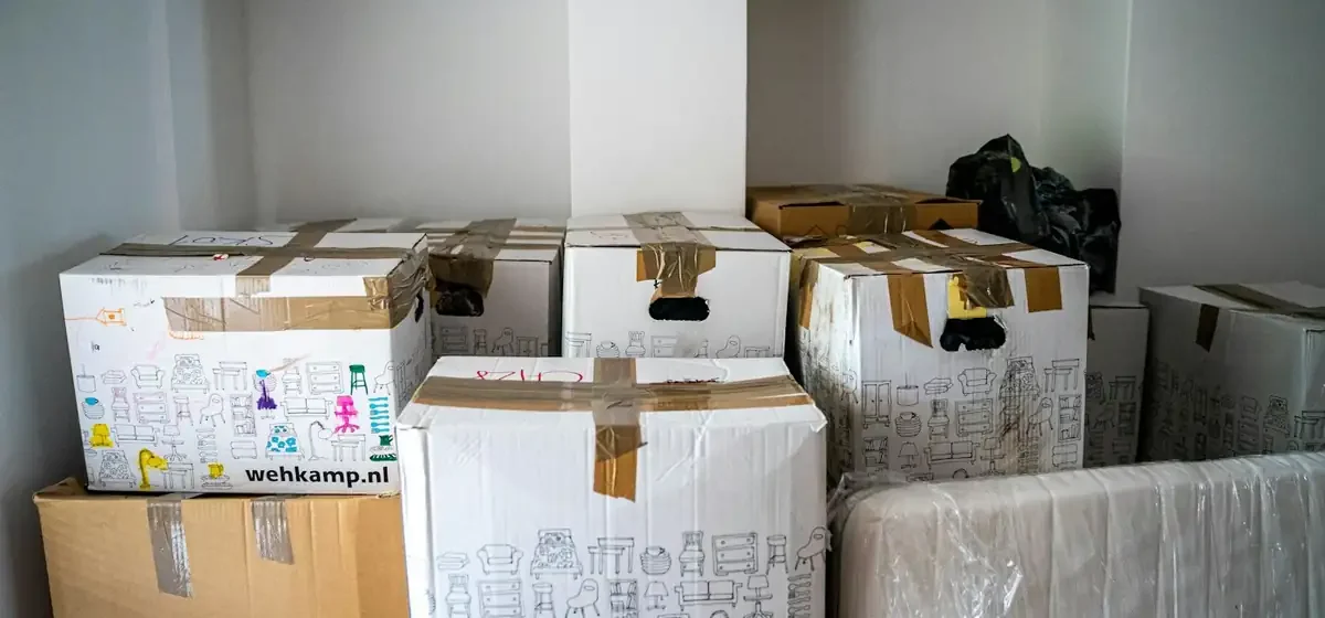 Taped cardboard moving boxes stacked against a wall