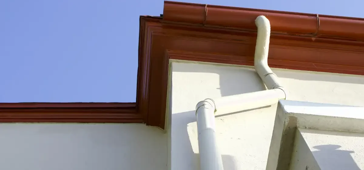 Guttering and downpipe at the edge of a roof